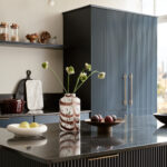 Dark Harvey Jones X Swoon cabinetry and kitchen island with black marble worktop featuring reeded detailing
