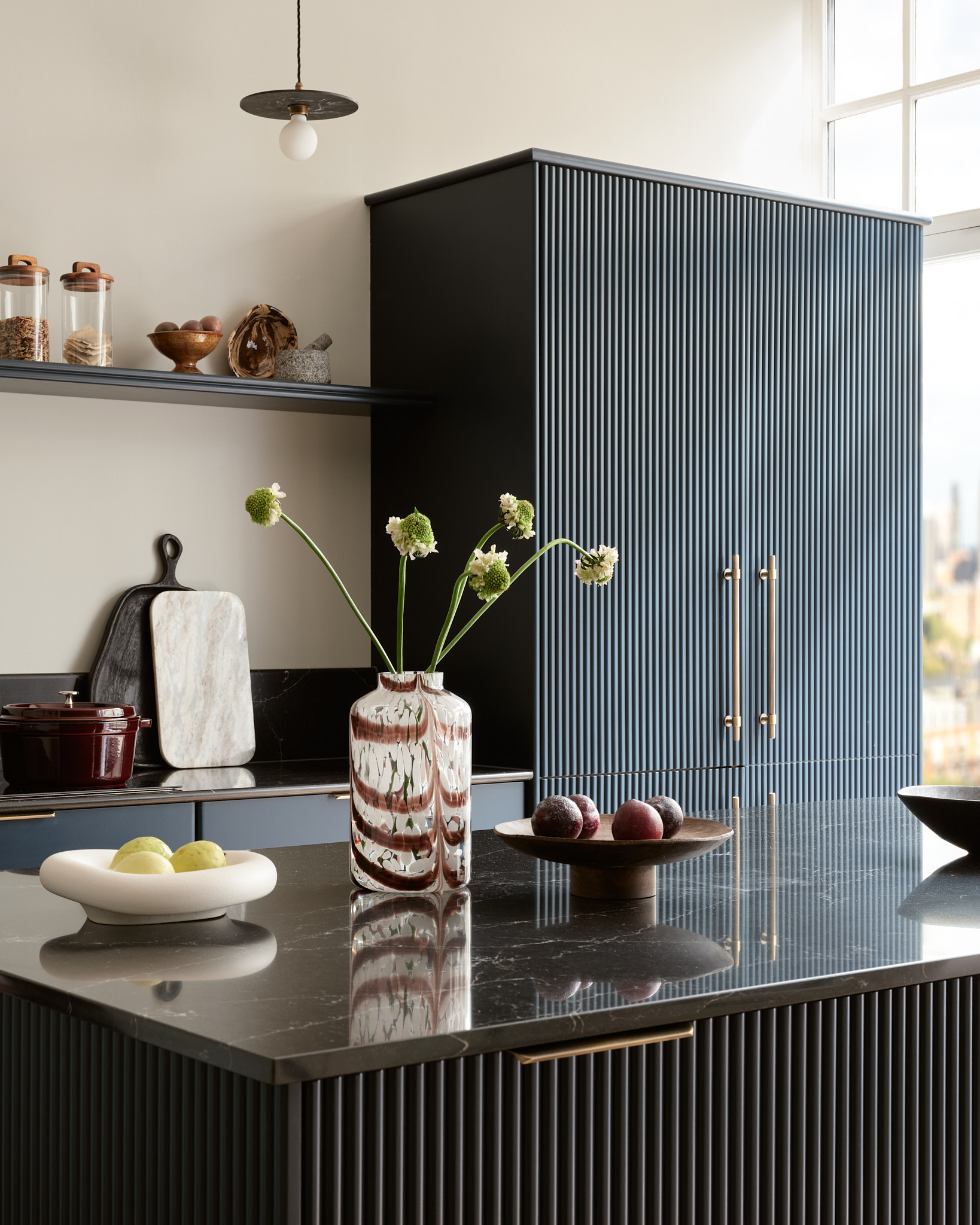 Dark Harvey Jones X Swoon cabinetry and kitchen island with black marble worktop featuring reeded detailing