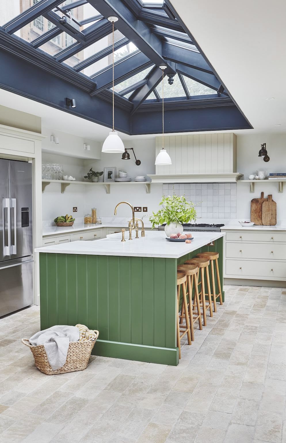 Green kitchen island with white worktop and white kitchen cabinetry
