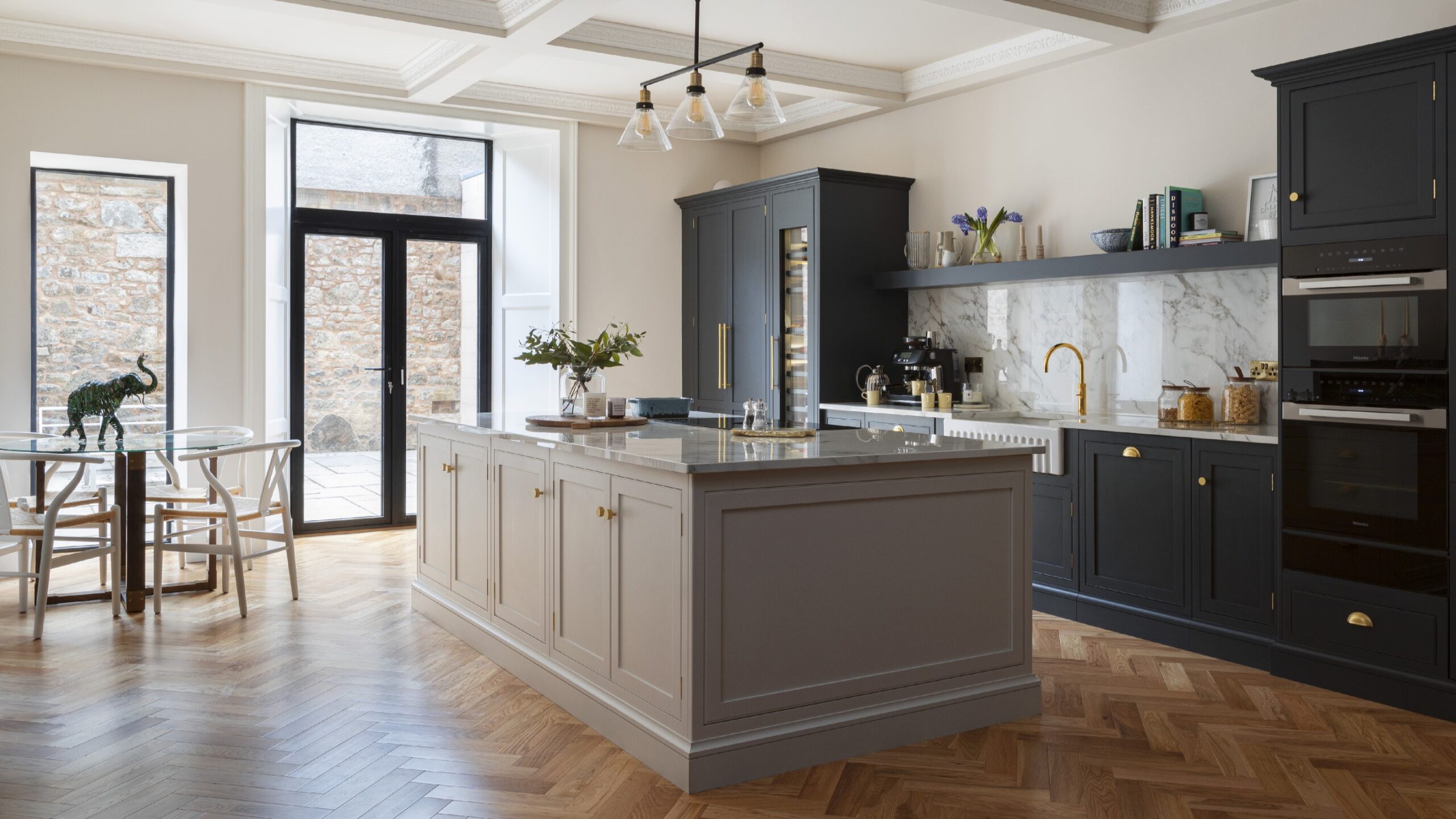 Beige kitchen island with grey worktop and dark kitchen cabinetry