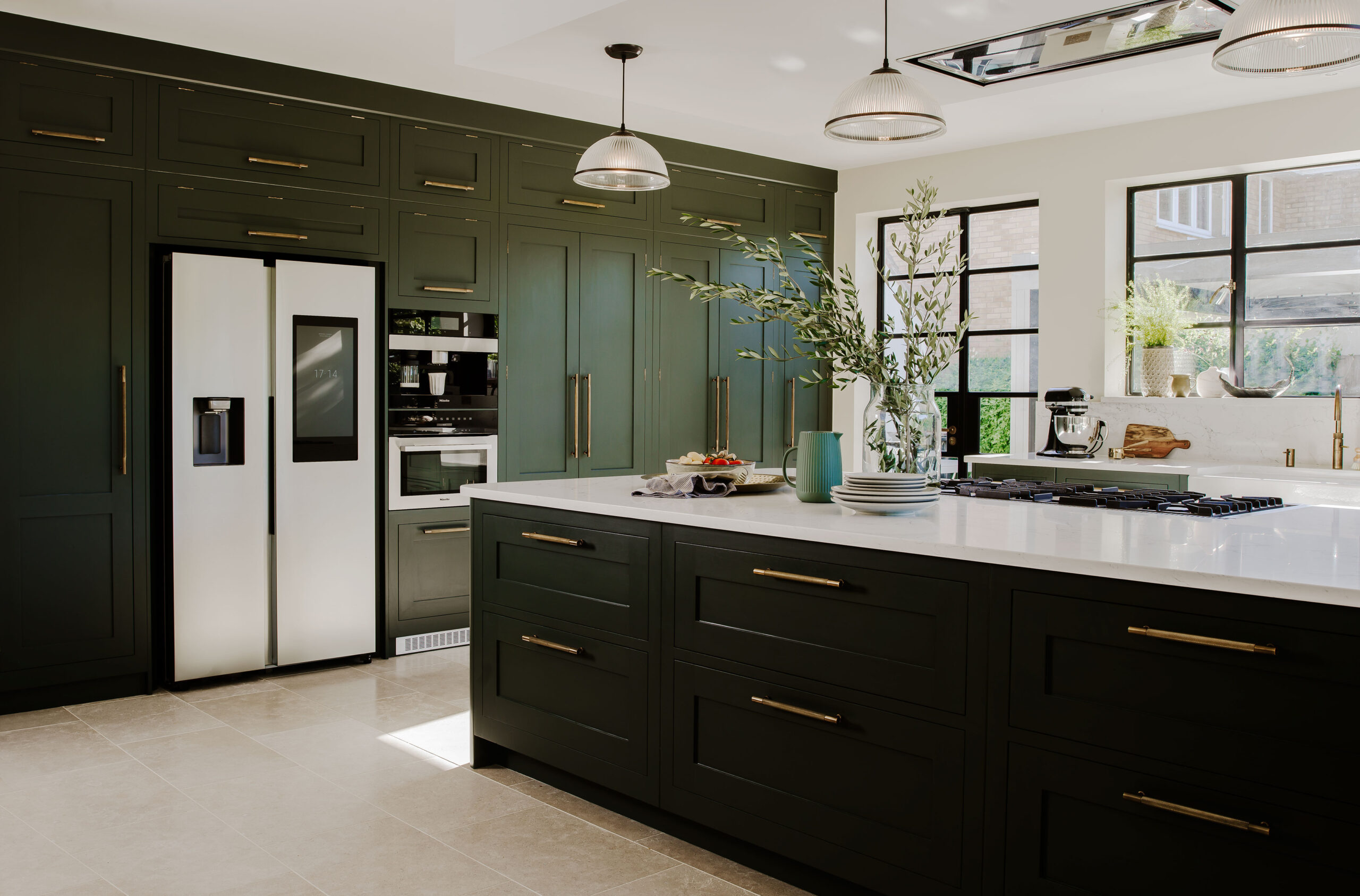 Kitchen appliances featured in a Harvey Jones kitchen with luxury island and dark green cabinetry