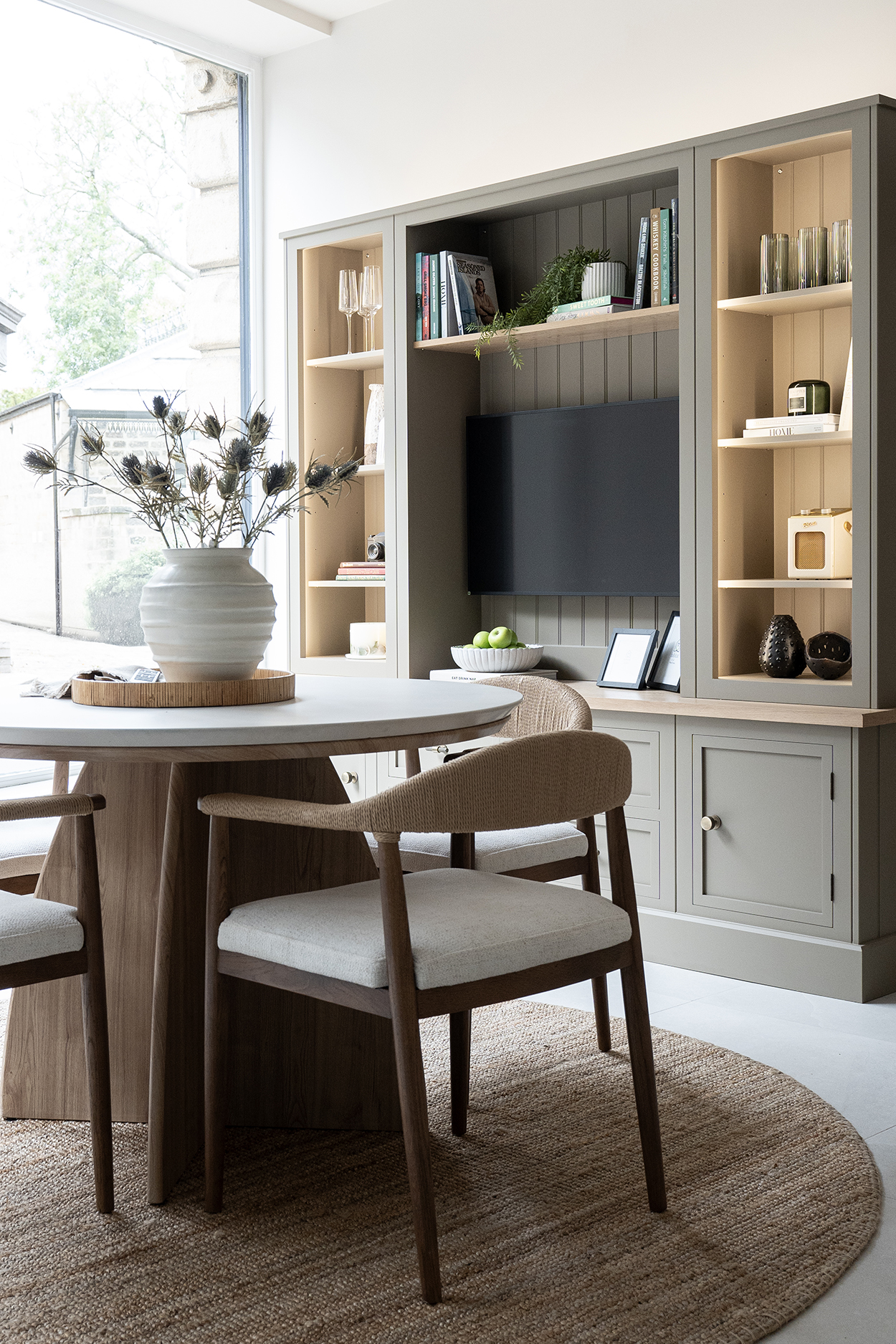 bespoke media furniture hand-painted in green with chair in foreground