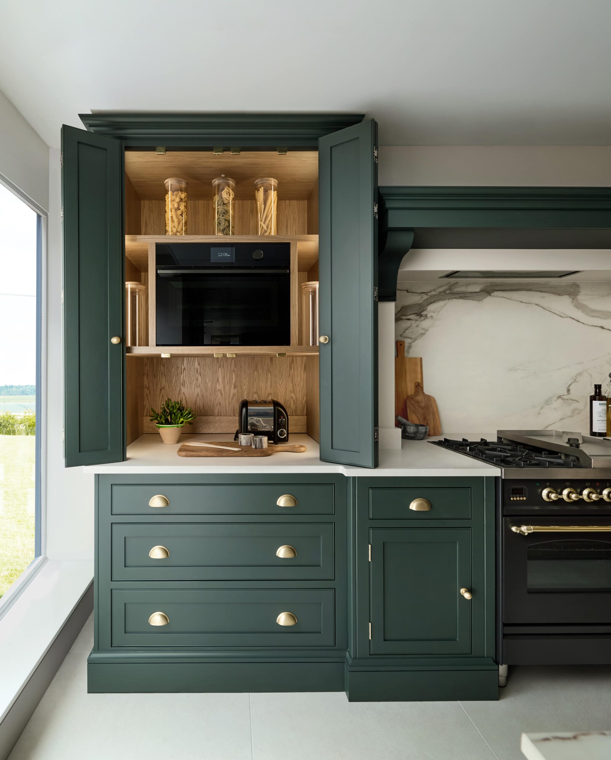 Green Shaker kitchen double dresser open to show hidden workspace and organised storage
