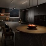 Black Contemporary Harvey Jones kitchen at night time.