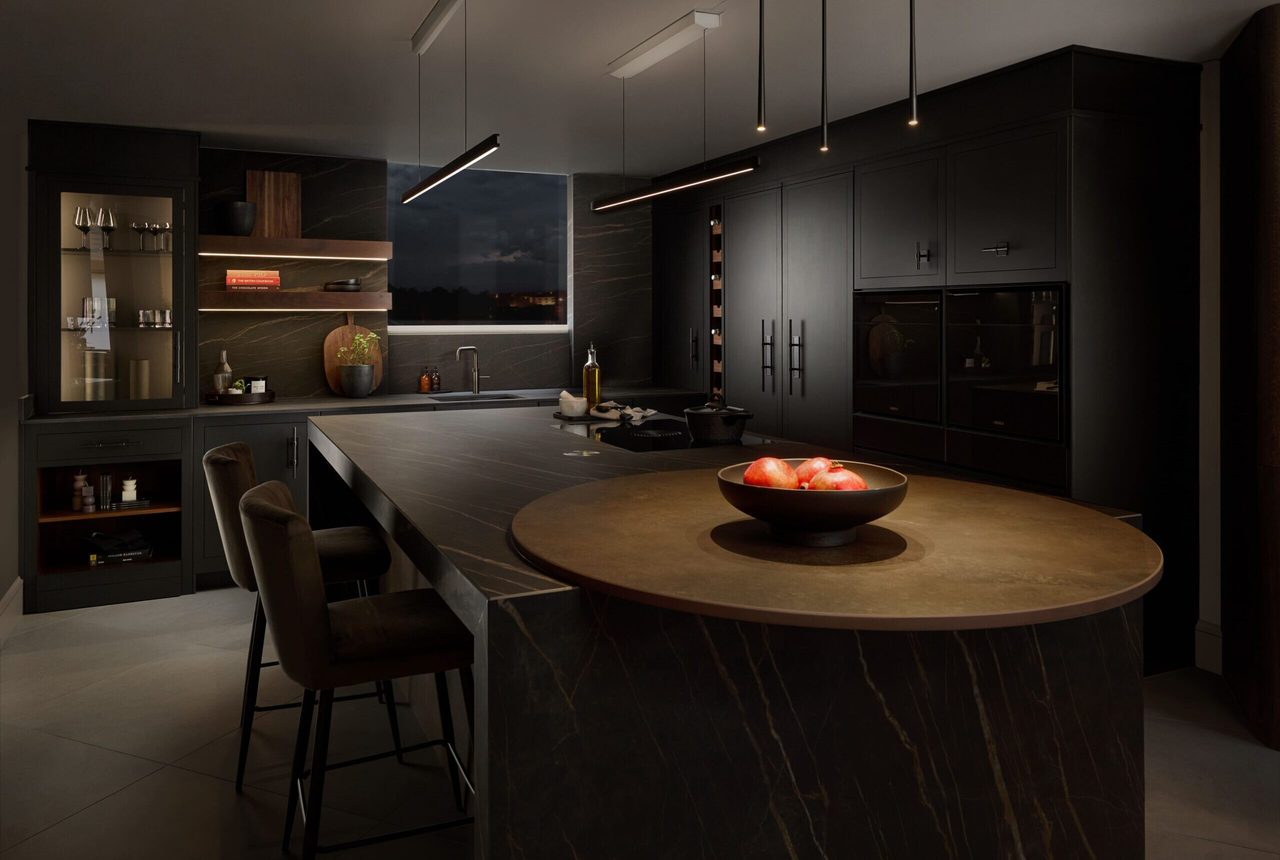 Black Contemporary Harvey Jones kitchen at night time.