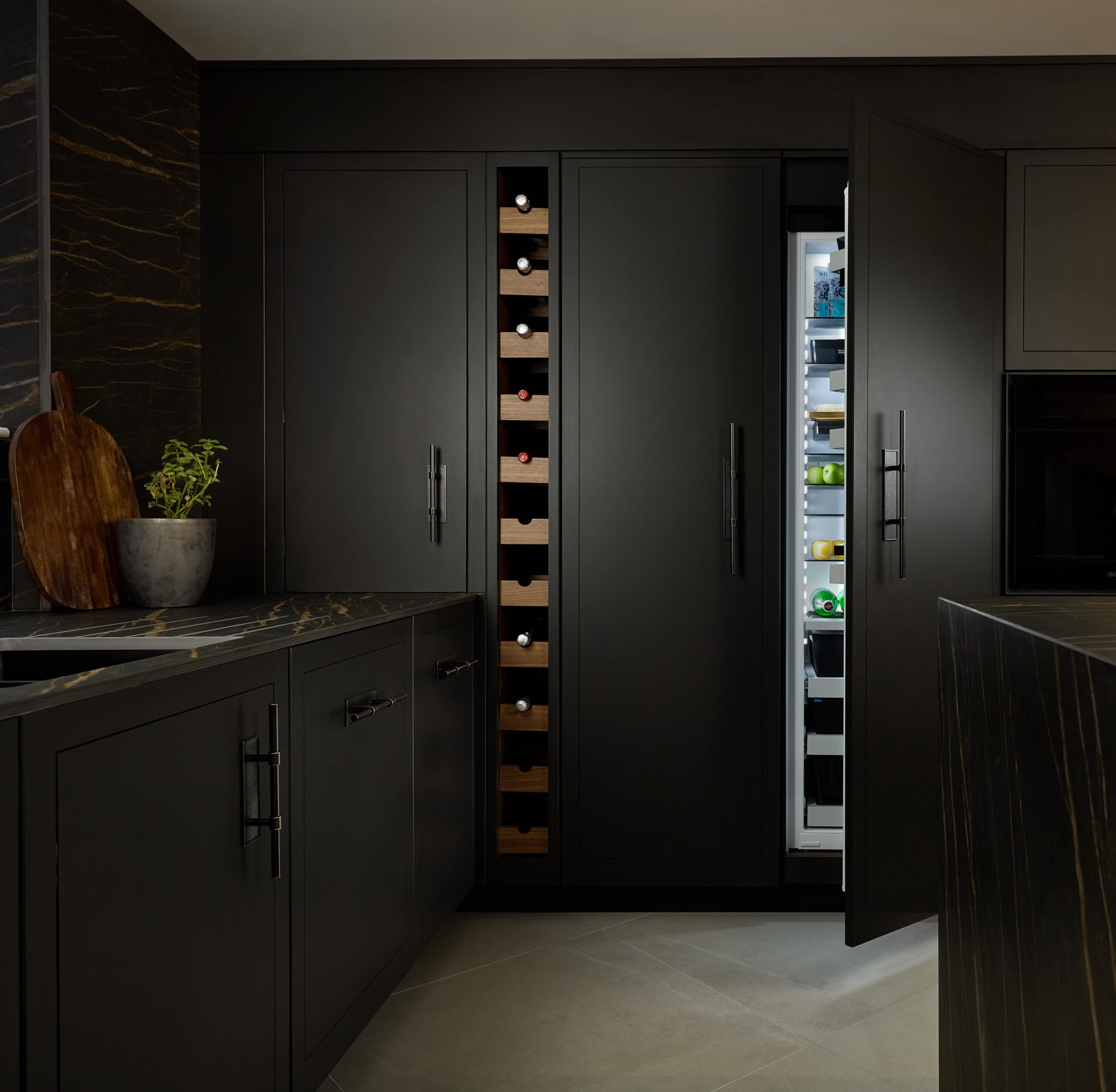 Black Contemporary Harvey Jones kitchen with BORA fridge and walnut wine rack.