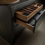 Black Contemporary Harvey Jones kitchen with two-tier walnut cutlery drawers.