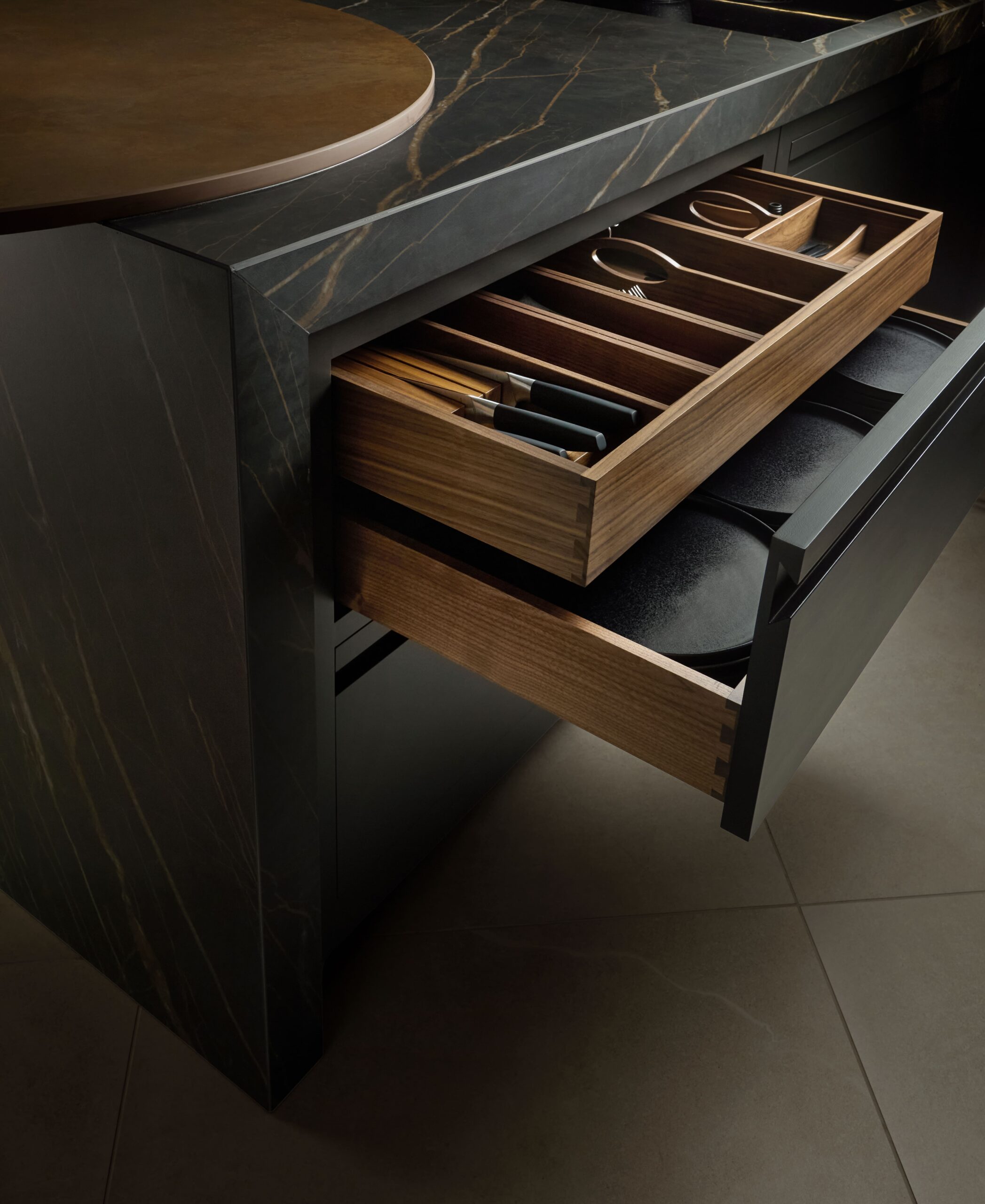 Black Contemporary Harvey Jones kitchen with two-tier walnut cutlery drawers.