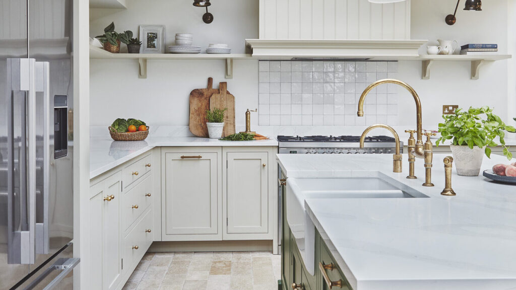L shaped kitchen with island sink and luxury white and green cabinetry