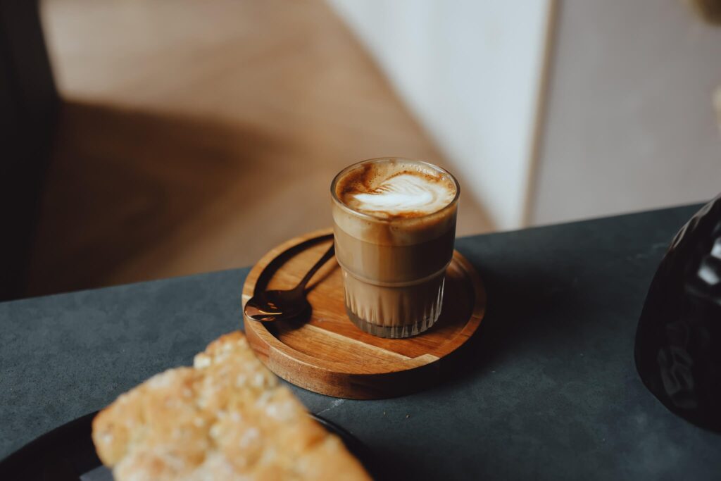 coffee in a glass mug on a wood saucer