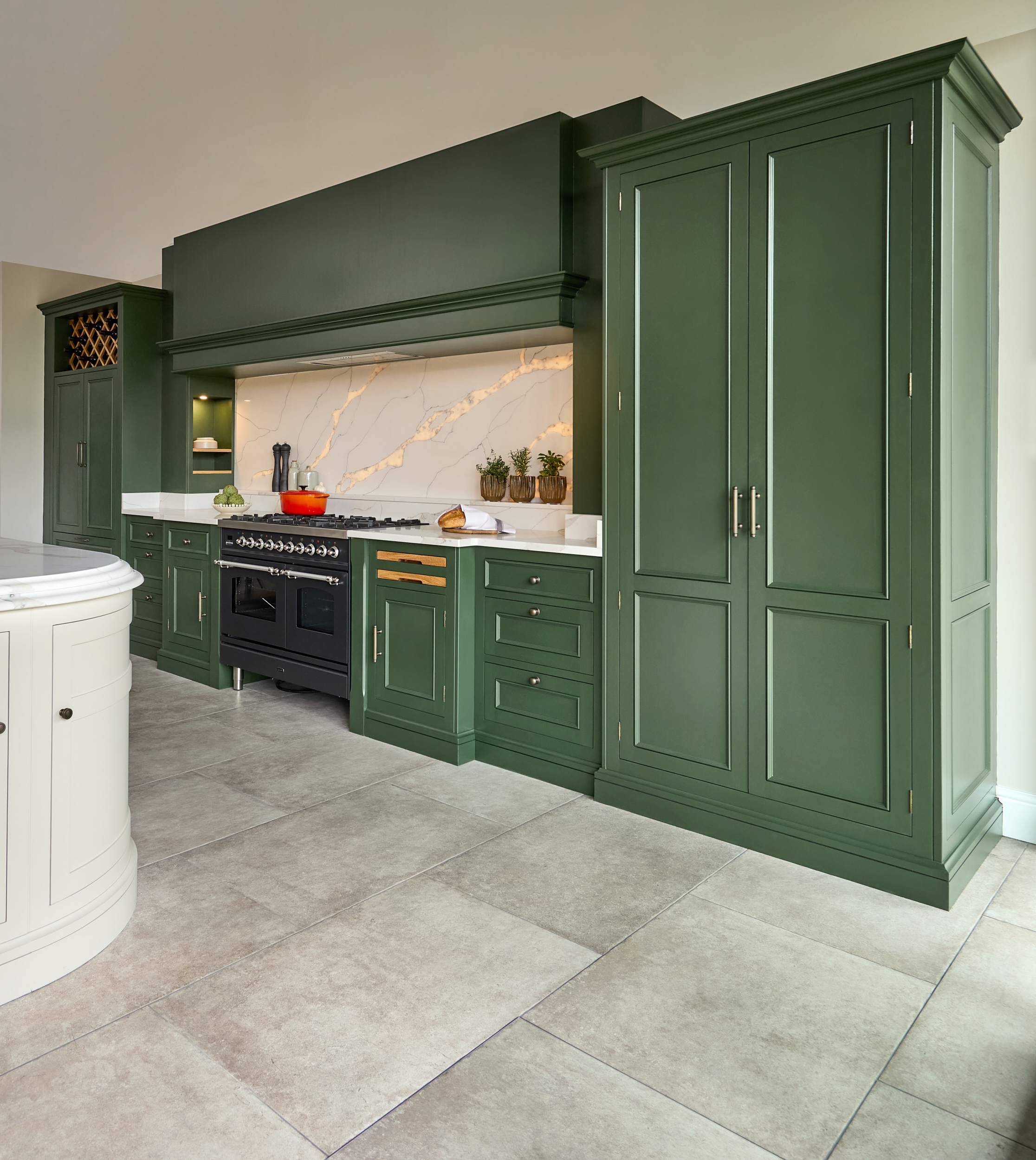 Green Kitchen with beige floor tiles and orange pot on the range cooker