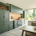 Green Kitchen with beige floor tiles and family dining table in the foreground