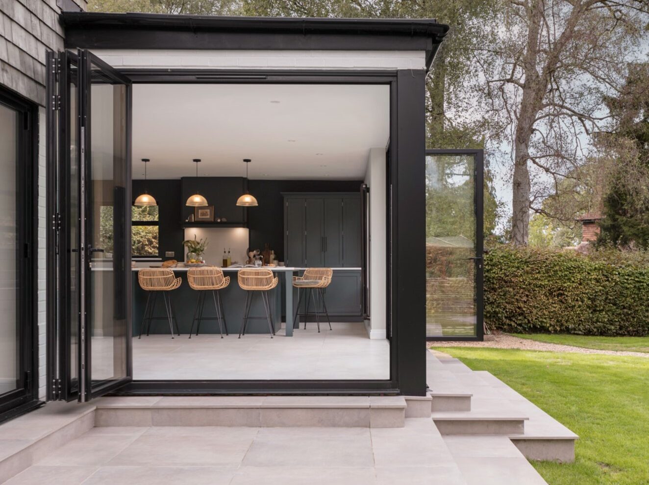 Beautiful garden with patio area looking into a green kitchen