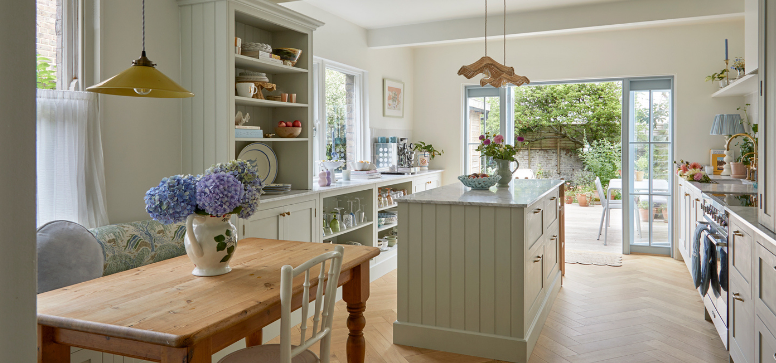 Sage green kitchen with open shelving and luxury pantry storage