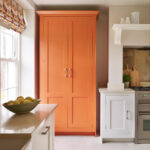 Orange larder in a neutral shaker kitchen.