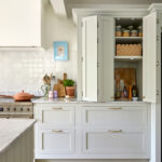 A luxury kitchen, breakfast dresser displays a stunning white marble centerpiece, accented with a golden knob and sleek modern design. The drawers, seamlessly integrated, create a harmonious blend of elegance and warmth in the space.