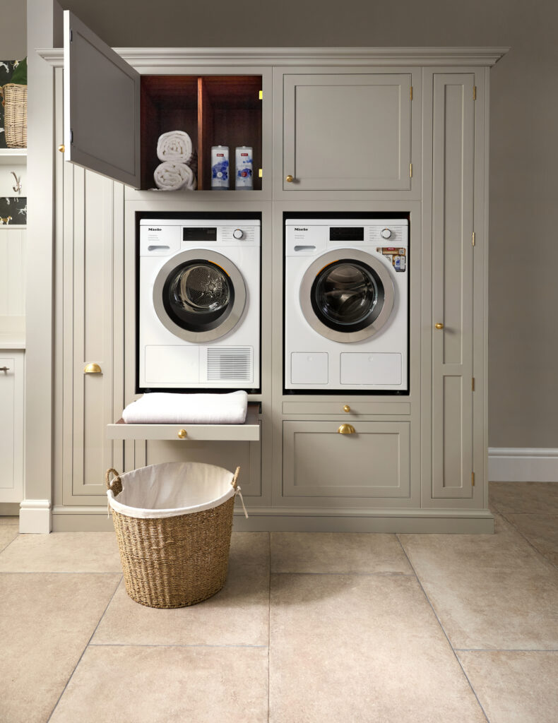 A modern laundry room featuring a washer and dryer, designed for efficient laundry storage in a luxury kitchen setting.