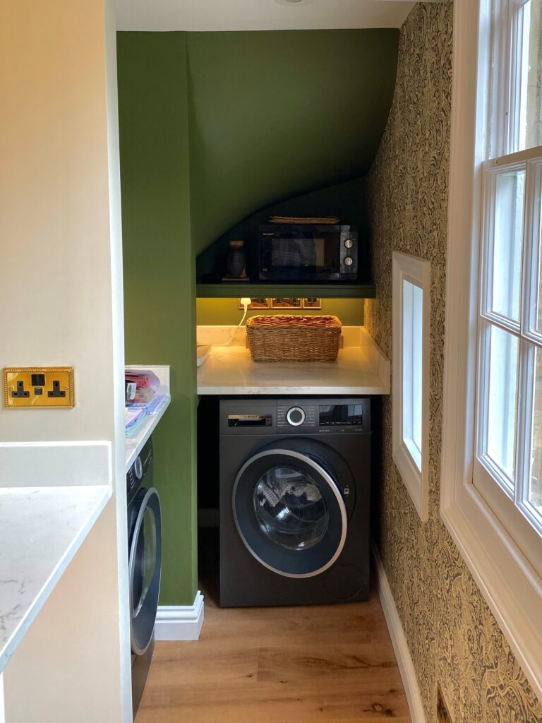  A small, bold laundry room featuring a washer and dryer, designed with ample storage for utility needs