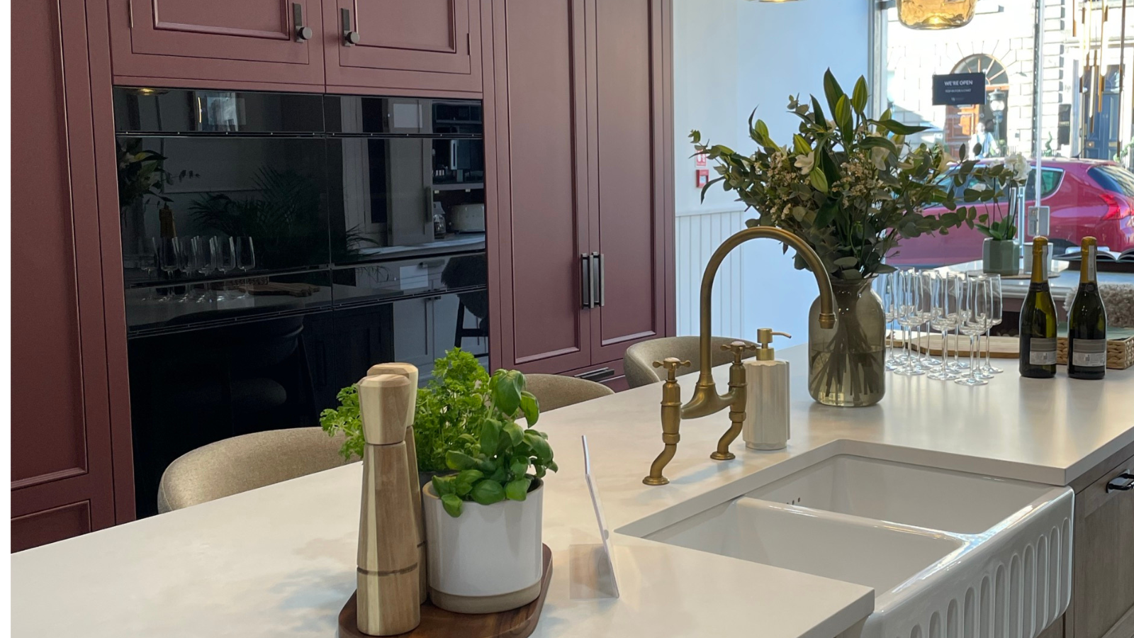 kitchen island with sink and burgundy cabinetry in the background