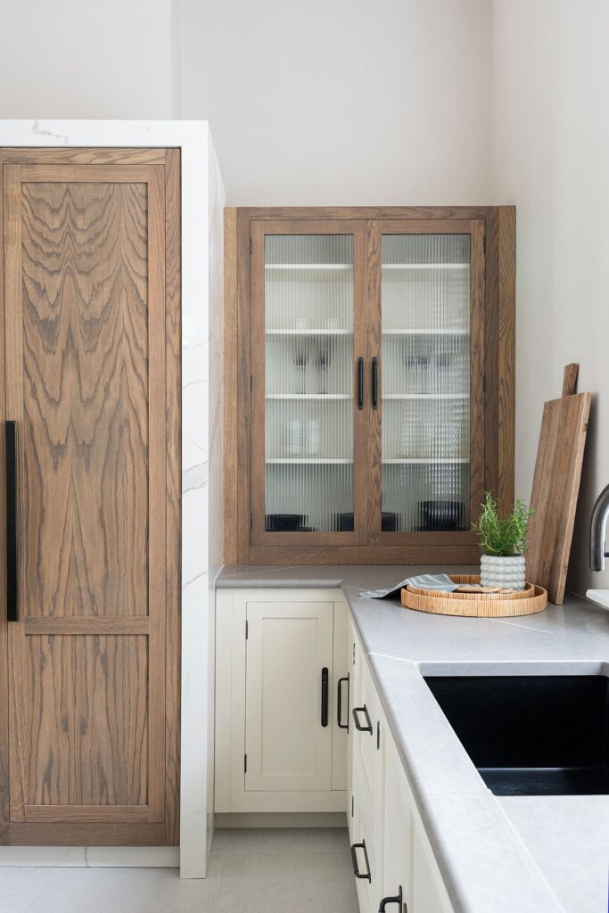 White Shaker kitchen cabinets with reeded glass wall unit