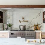 Marble splashback and brass pot filler in a luxury kitchen design.