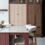 Closed pink breakfast dresser framed by walnut tall kitchen cabinetry.