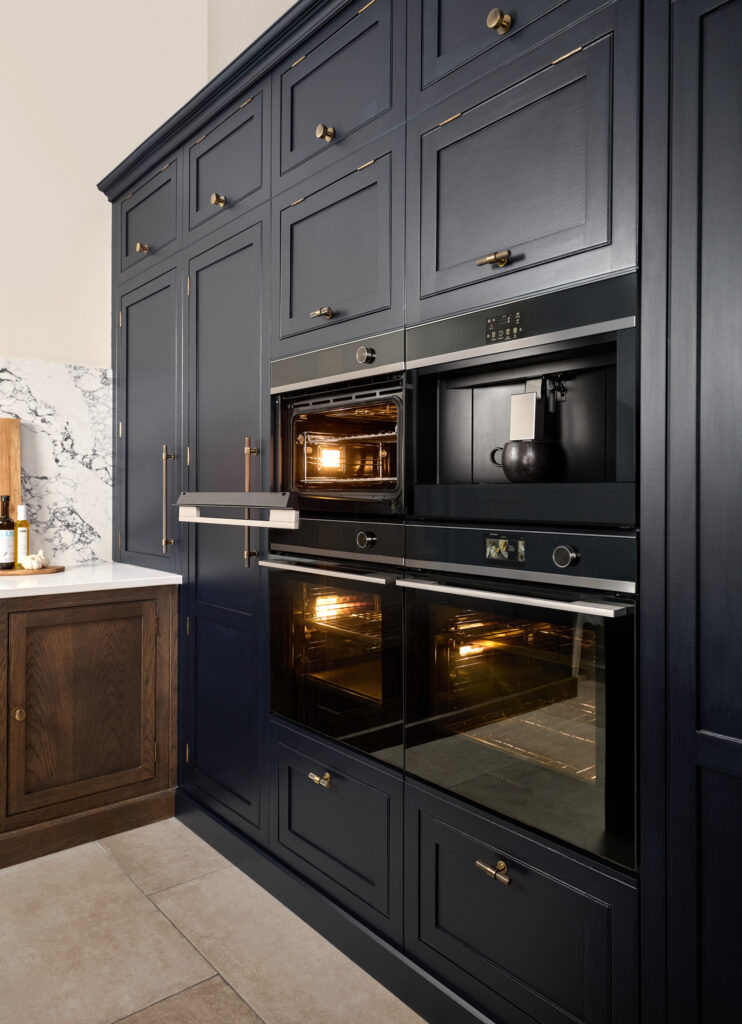 Integrated ovens in a navy blue bespoke kitchen