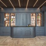 Full wall of dark bespoke kitchen cabinetry with illuminated timber shelving and curved center cabinets.