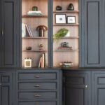 Bespoke dark kitchen cabinetry with curved detailing and walnut-toned shelving.