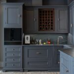 Dark bespoke kitchen cabinetry with integrated storage, wine rack, and copper fixtures.