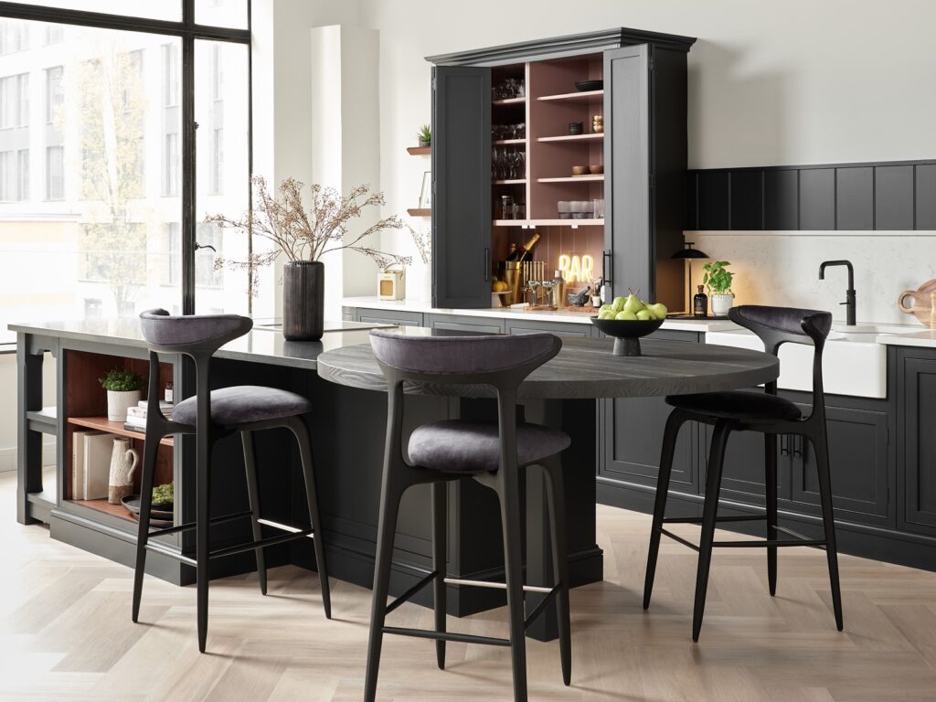 Bright open plan black kitchen featuring hidden bar and ambient lighting