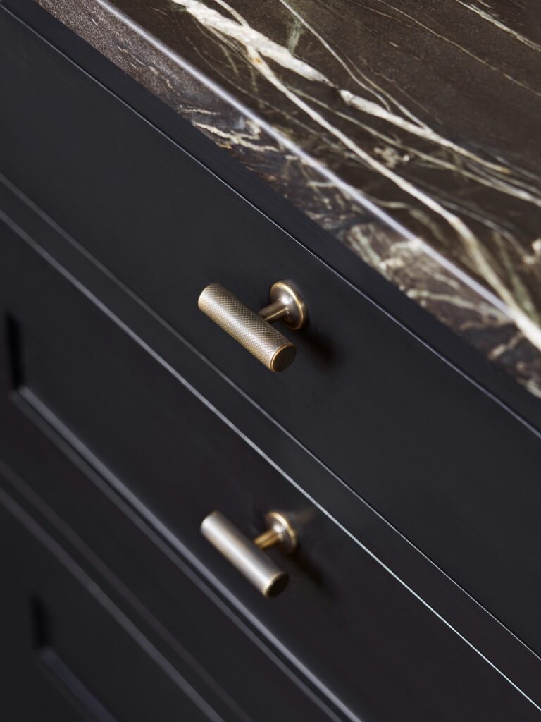 Marble countertop and dark cabinetry in a luxury dark kitchen