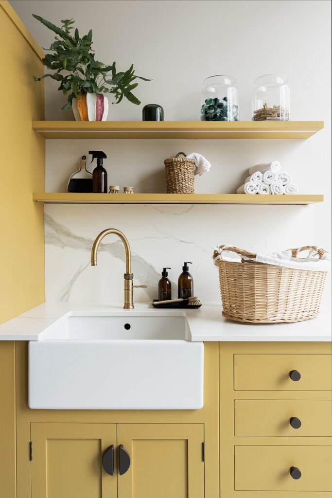 Yellow bespoke utility room with open shelving and belfast sink