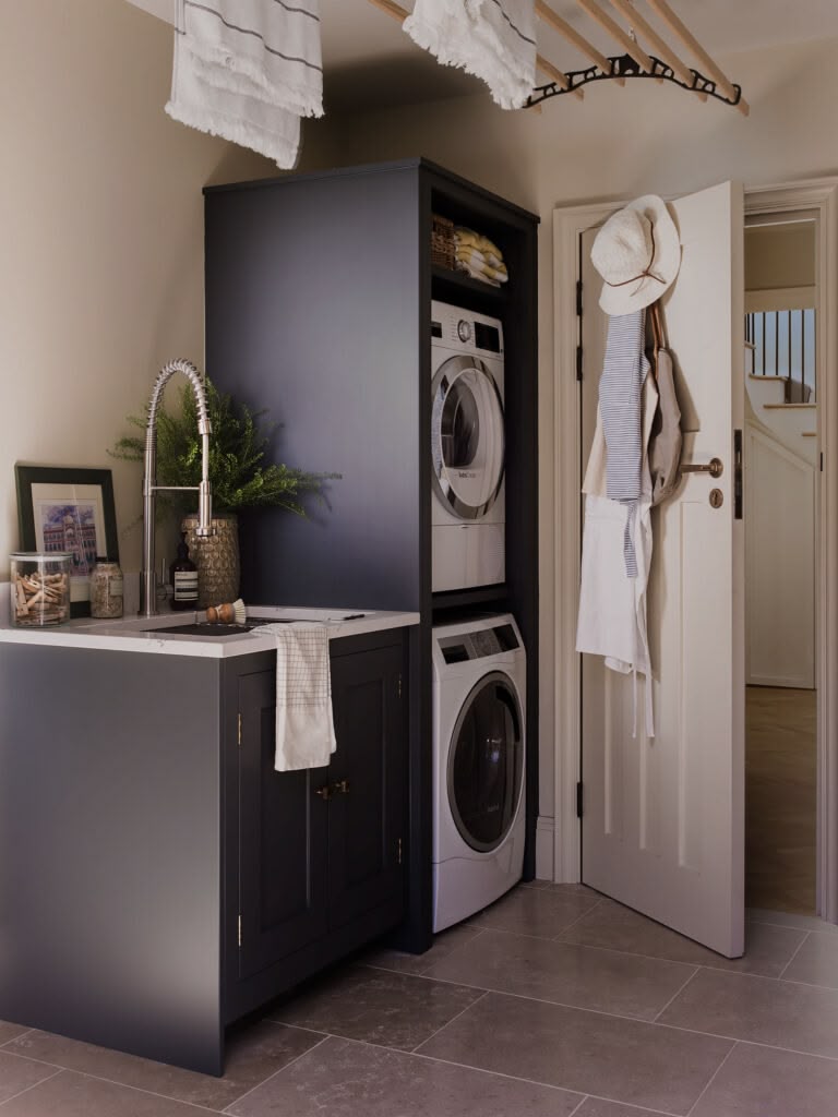 Small utility room with zoned laundry area with stacked washing machine and dryer