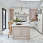 Open plan bespoke kitchen design with pink tiles and airy feel