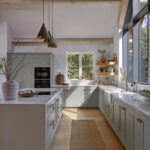 Light blue Shaker kitchencabinets with brass knobs and classic detailing