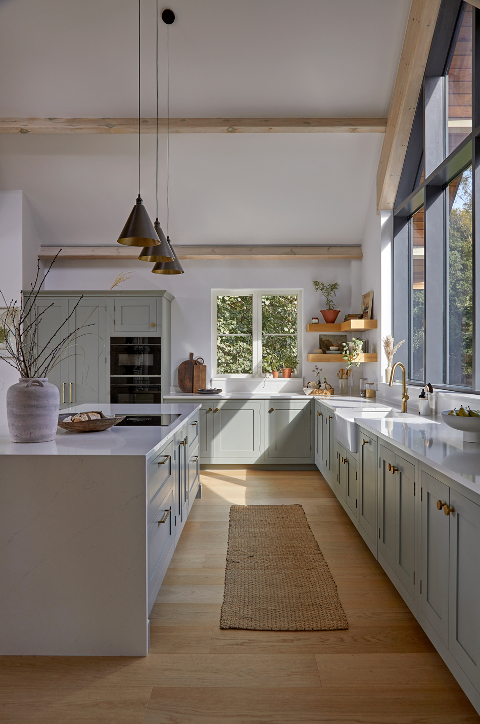 Light blue Shaker kitchencabinets with brass knobs and classic detailing