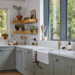 Open wooden shelving in a light blue Shaker kitchen with bespoke design displaying plants and ceramics.