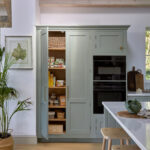 Tall pantry cabinets offering bespoke storage in a blue Shaker kitchen