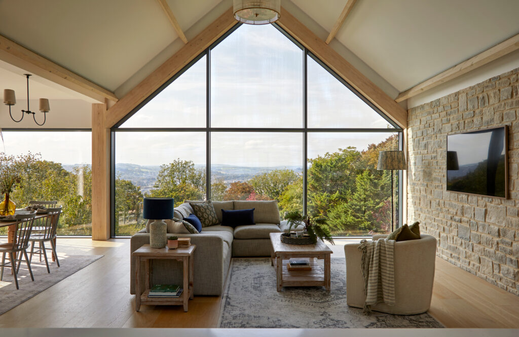 Open plan luxury kitchen flowing into dining and living areas with coordinated finishes.