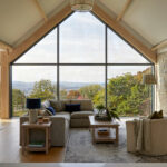 Open plan luxury kitchen flowing into dining and living areas with coordinated finishes.