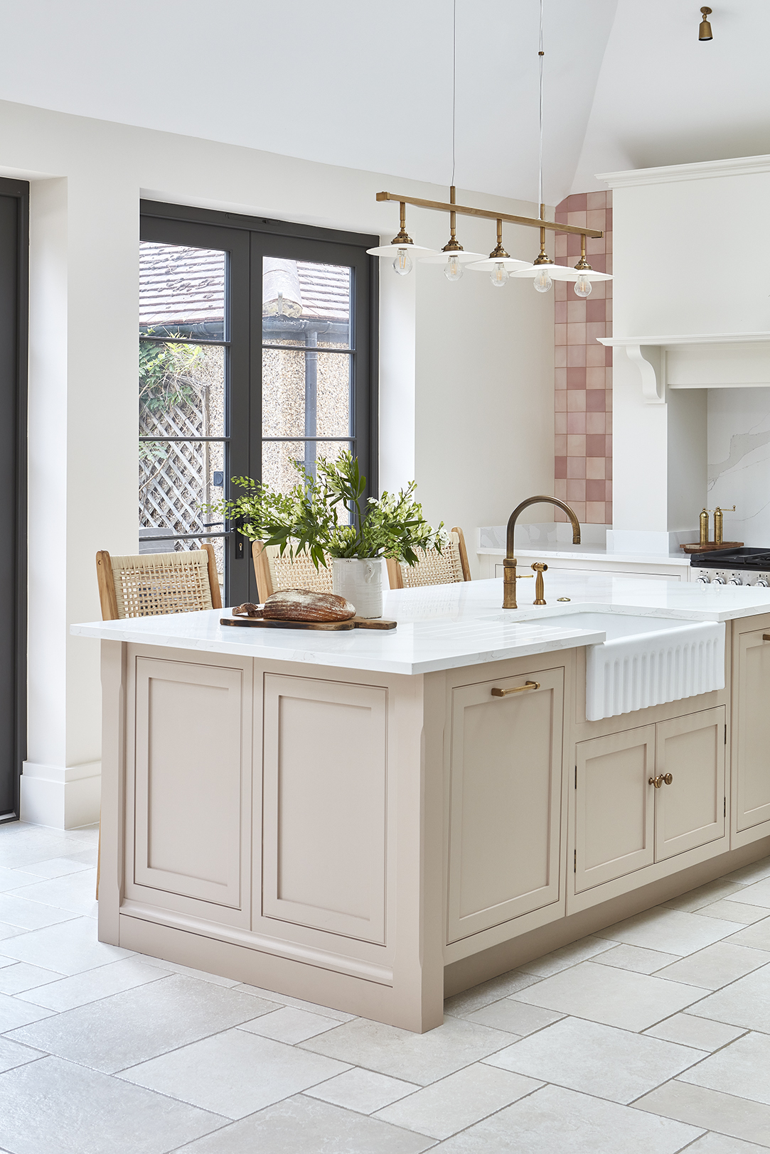 Soft pink kitchen island with marble worktop and belfast sink
