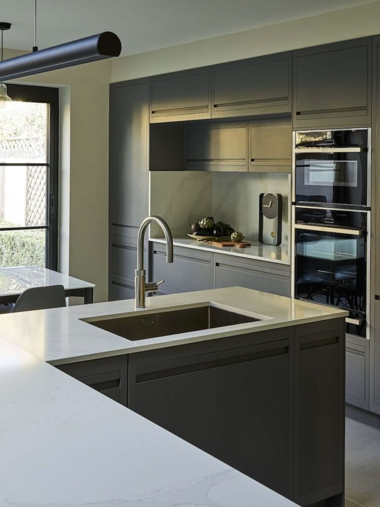 Moody industrial kitchen design with L shaped island and seamless design