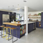 Navy handleless Linear Edge kitchen with quartz island, open shelving and integrated wine fridge in a bright open plan space.