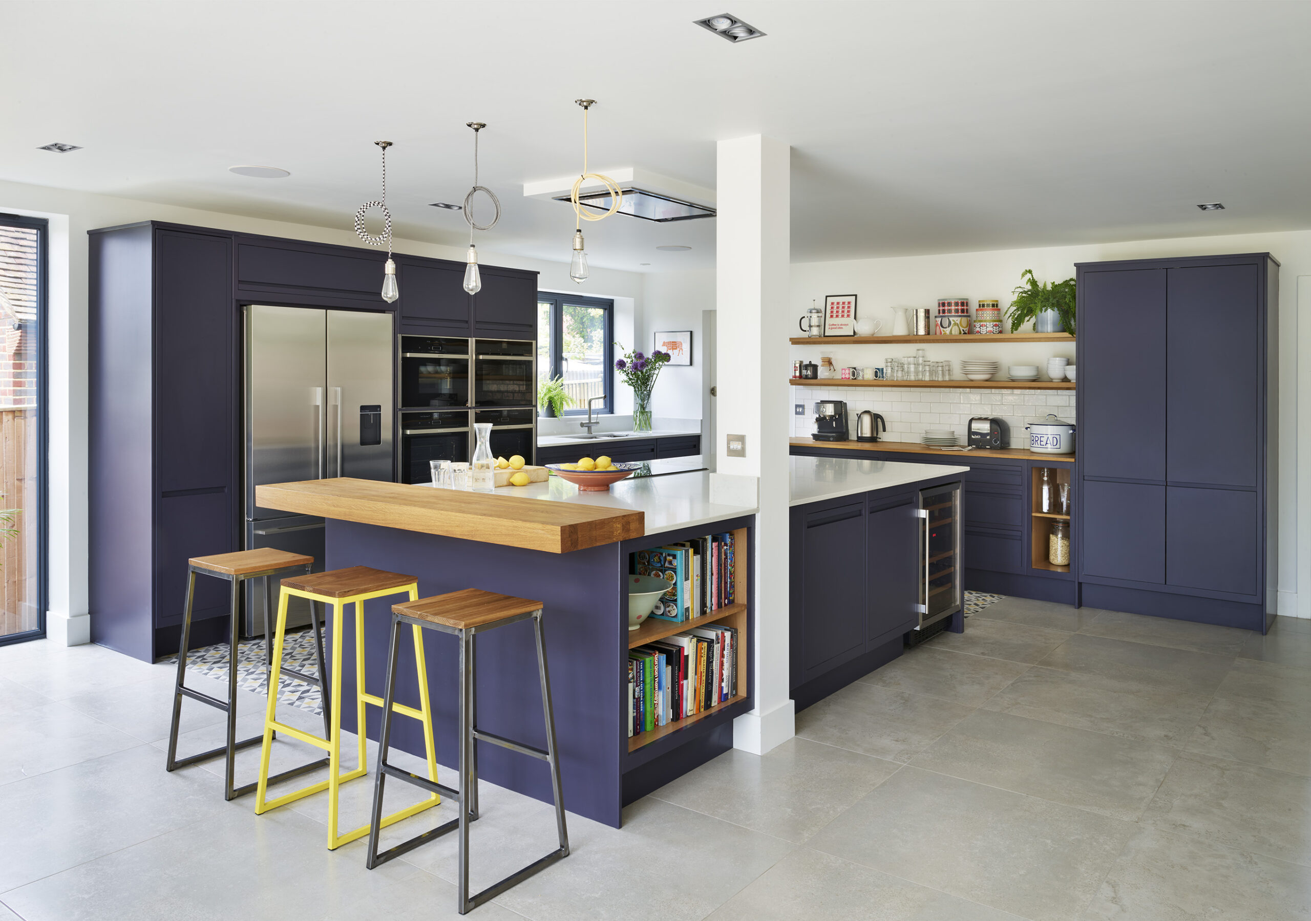 Navy handleless Linear Edge kitchen with quartz island, open shelving and integrated wine fridge in a bright open plan space.
