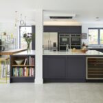 Modern navy kitchen island with off white quartz worktop, stained oak breakfast bar and integrated storage drawers.