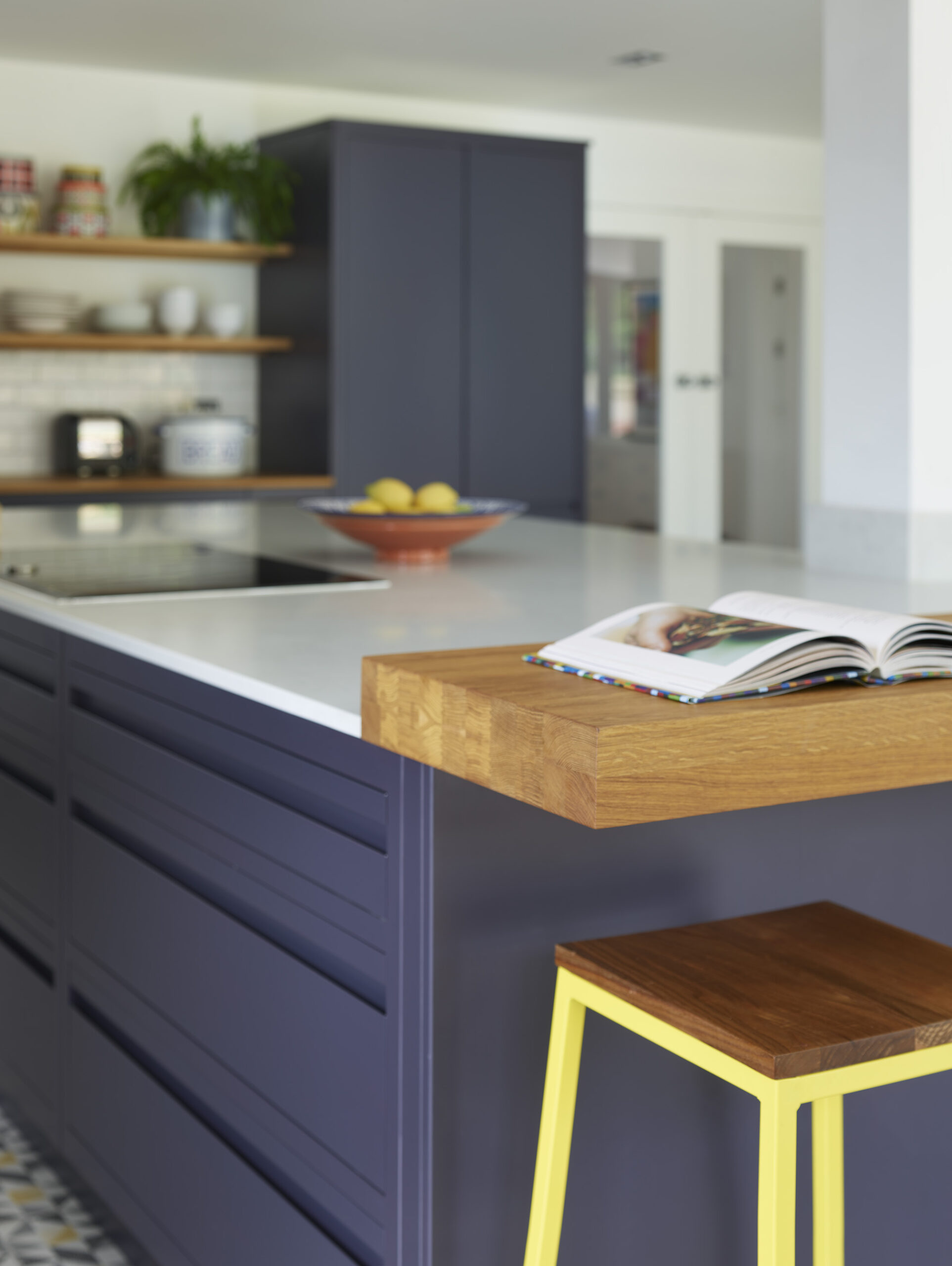 Handleless navy kitchen design with stained oak worktops adding warmth and contrast to modern cabinetry.