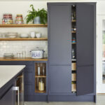 Modern Linear Edge kitchen showcasing bold navy cabinetry balanced by light quartz worktops and warm wood tones.