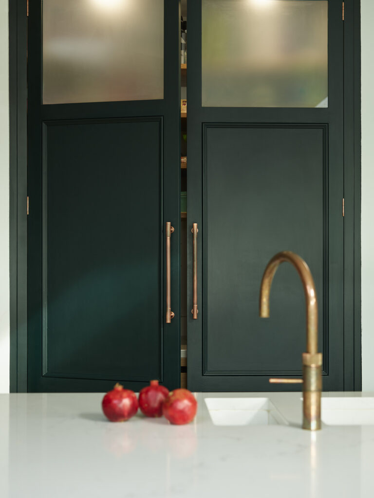Forest green kitchen with brass hardware