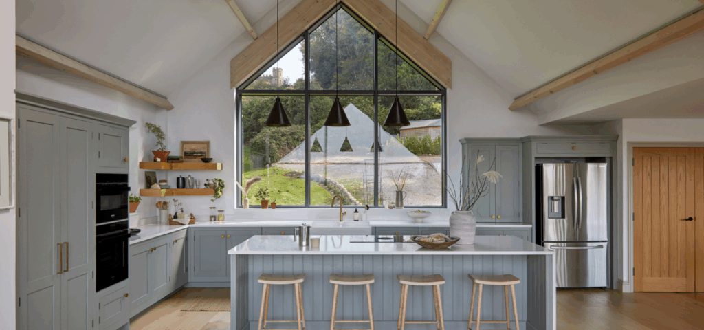 Light blue Shaker kitchen island with white quartz worktop and integrated seating.